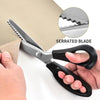 A pair of silver serrated fabric shears is shown being used to cut a piece of brown paper.