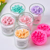 A collection of silicone molds shaped like pink, purple, and yellow flowers for making scented candles and soaps.