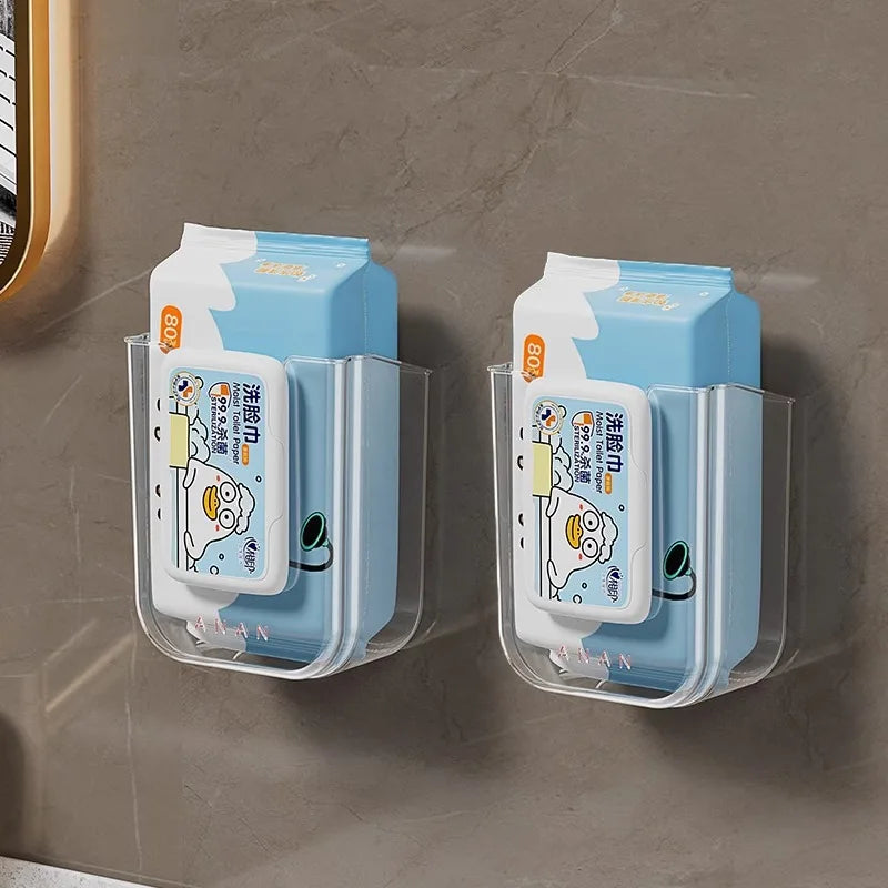 Wandmontierte Toilettenpapierdispenser mit blau-weißem Design an einer grauen Wand.