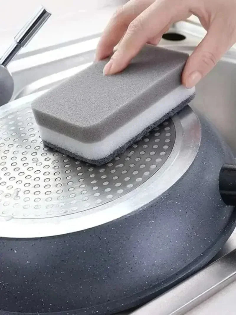 A hand places a gray cleaning sponge onto a silver dish rack for washing.