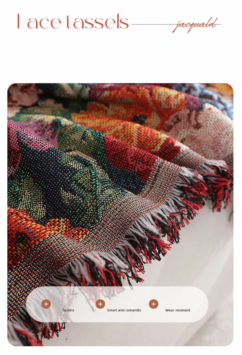 Close-up of a romantic floral jacquard sofa blanket with fringed tassels in rich jewel tones.