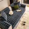 A dark gray plush sofa cushion cover featuring textured fabric and decorative pillows on a light-colored sofa.