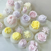 A collection of white silicone molds shaped like pink, purple, and yellow roses and peonies for crafting.
