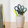 A collection of black and colored scissors with soft-grip handles displayed in a white pot.