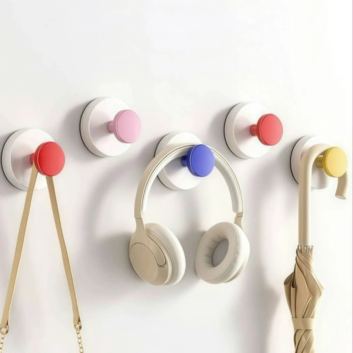 A collection of colorful suction cup hooks with various colored grips mounted on a white surface.