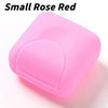 A small, pink, translucent silicone soap holder with a rounded lid.