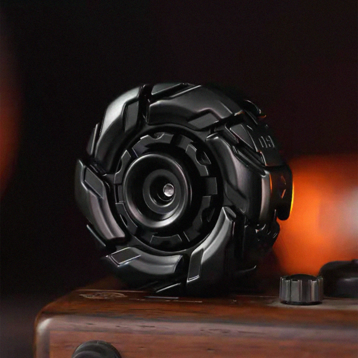 A black fidget spinner with a geometric design resting on a wooden surface.