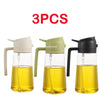 Three glass oil spray bottles with black and white tops for cooking