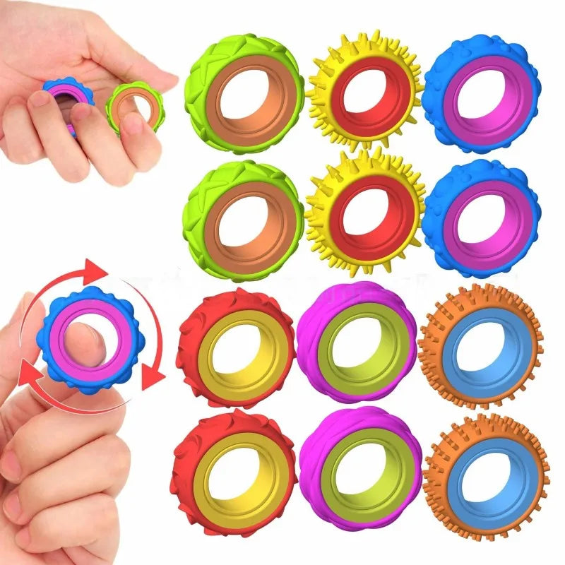 A hand holds various silicone fidget rings in bright colors including green yellow red purple and blue.