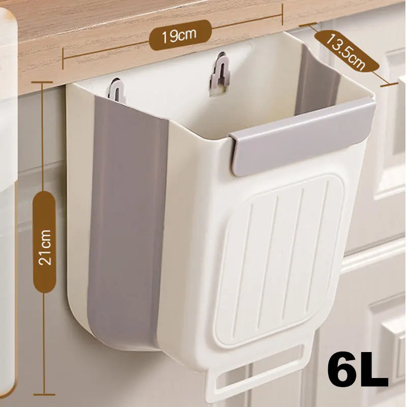 A white foldable hanging trash can with a gray lid and ribbed body is shown mounted on a cabinet shelf.