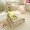 A beige lace-trim breathable summer duvet is displayed with decorative pillows and a small stuffed animal.