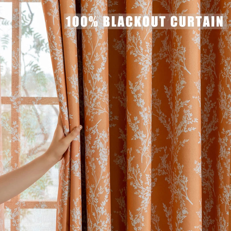 An orange curtain panel with a white plant pattern is shown being drawn across a window.