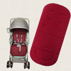 A silver baby stroller seat cushion is shown next to a red, padded seat cushion.