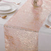A pink metallic gold glitter table runner displayed on a white tablecloth with tableware.