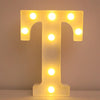 A glowing yellow LED letter T night light with multiple illuminated dots on a white surface.