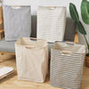 Three fabric laundry baskets in striped and checkered patterns are displayed on a wooden floor.