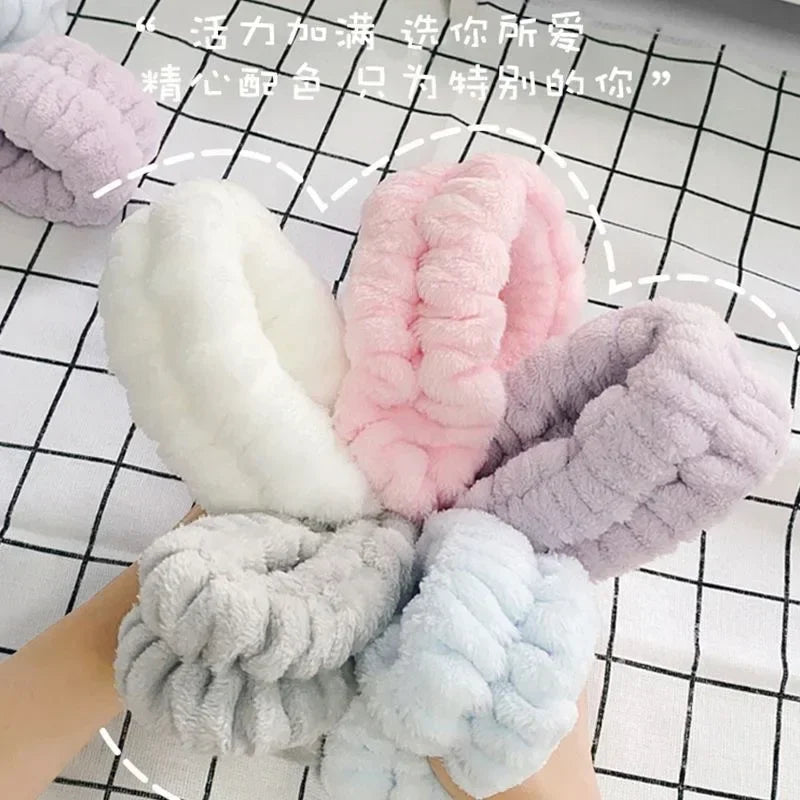 A collection of soft, fluffy microfiber wrist sweatbands and scrunchies in various pastel colors like pink, lavender, white, 