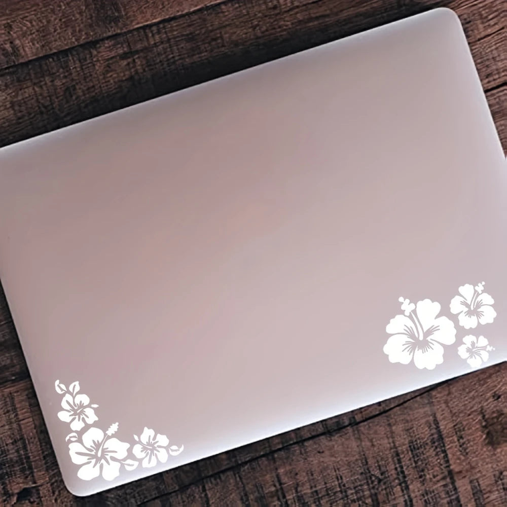 A white laptop is shown on a wooden surface with a floral decal design.