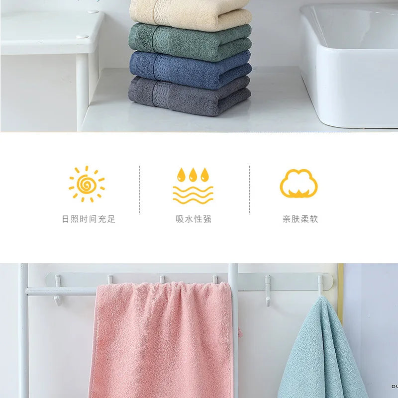 A set of six folded, soft cotton face towels in various shades of green and blue are displayed on a white shelf.