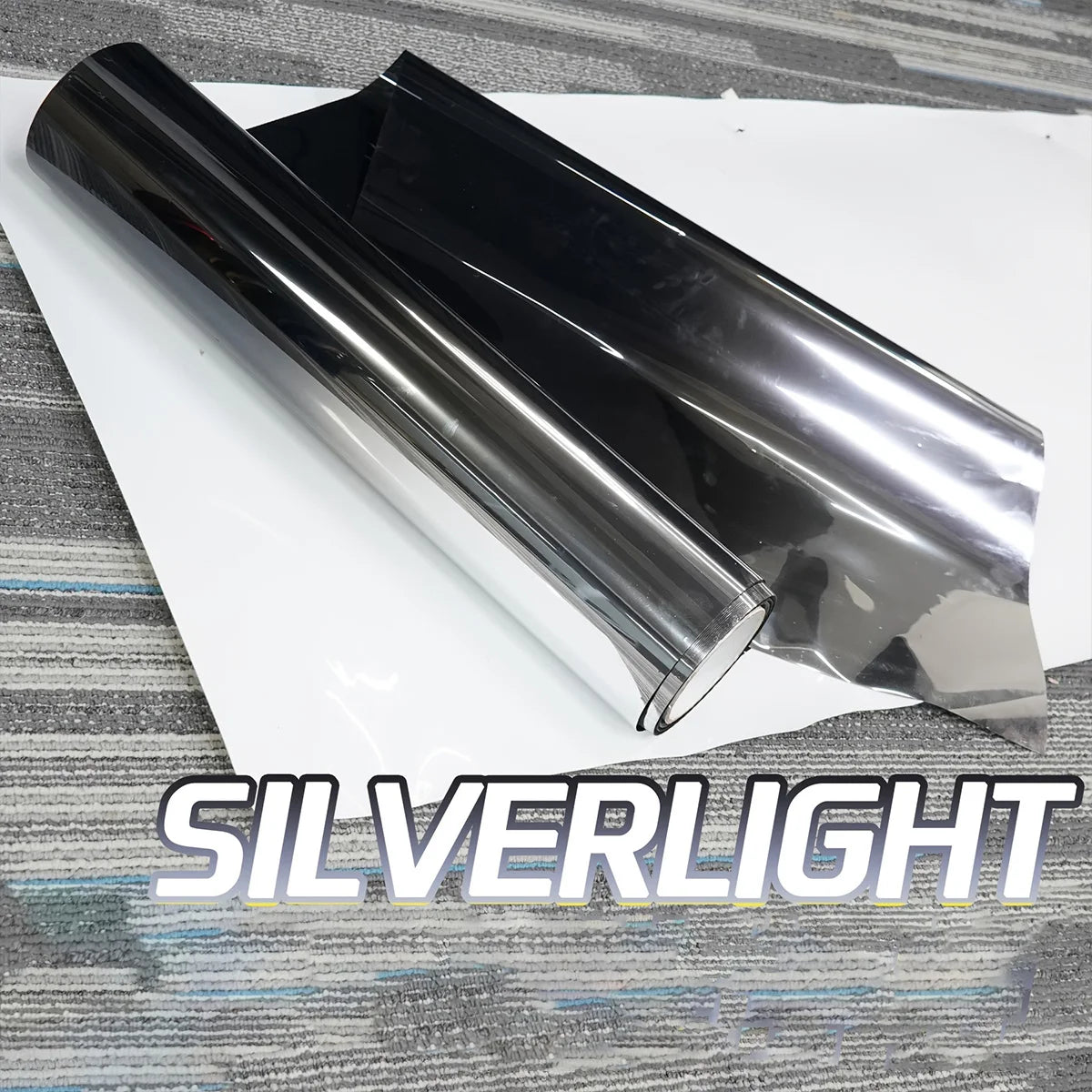 A roll of silverlight gradient car window tint film lying on a white surface.