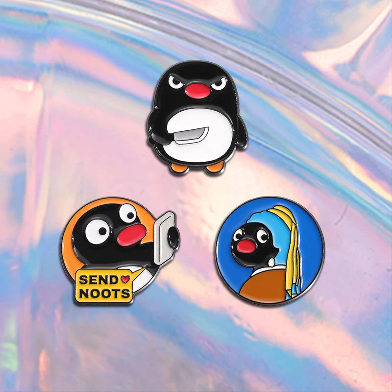 A set of three enamel pins featuring a cartoon penguin character with various expressions and accessories.