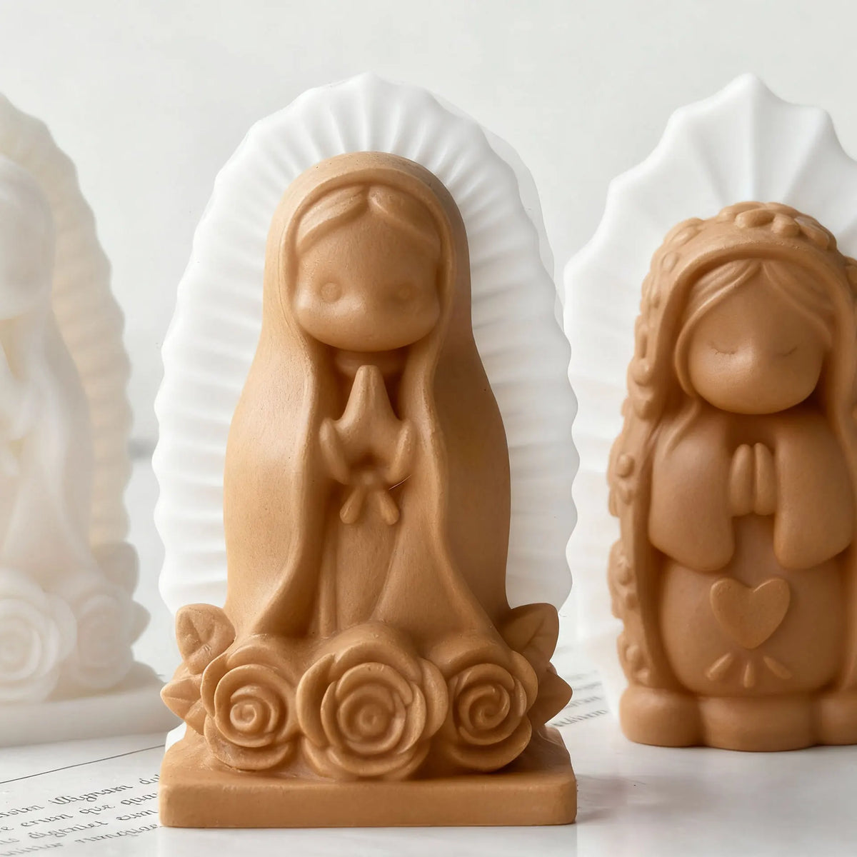 A terracotta silicone mold of a praying girl figure used for candles, soap, and craft decor.