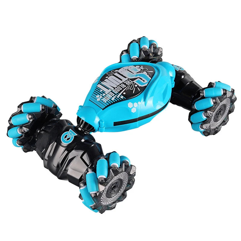 A close-up view of a black and blue RC stunt car with large tires and a transparent body.