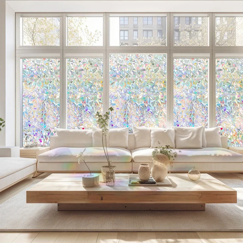 A modern living room featuring a large window covered with colorful 3D rainbow privacy film and a light-colored sofa.