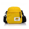 Yellow mini canvas crossbody bag with black strap and a white label on the front