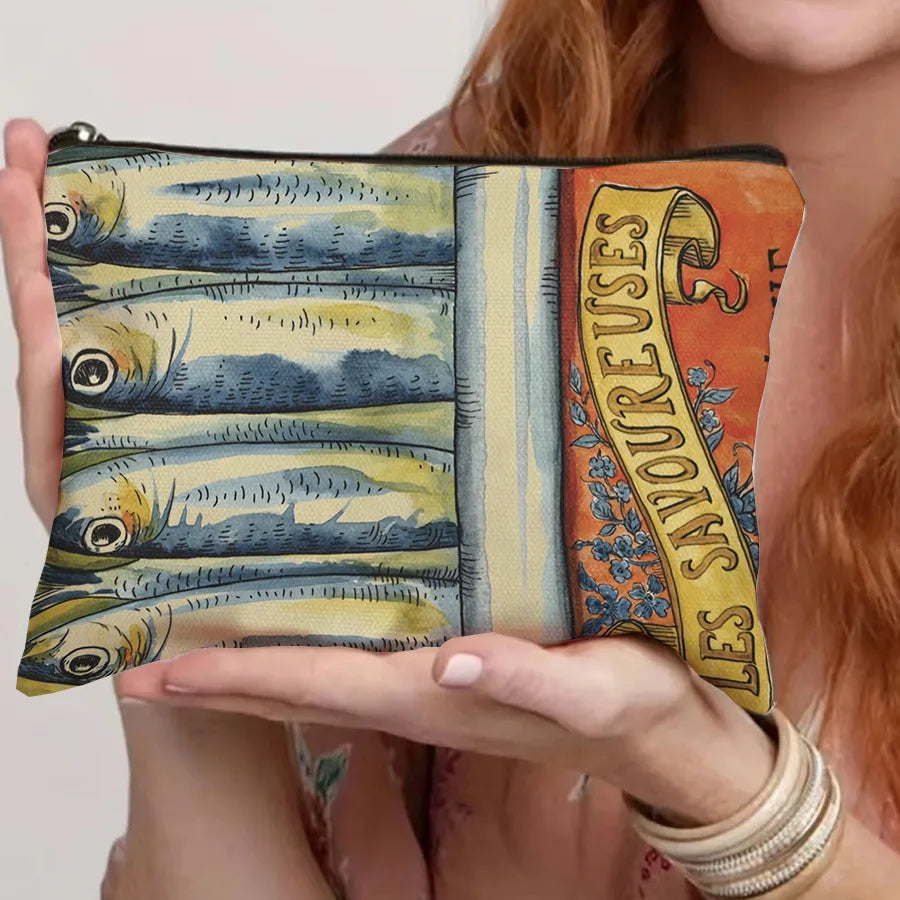 A canvas cosmetic bag featuring a vintage sardine print design on the front.