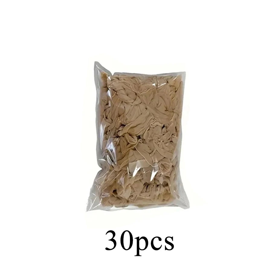 A clear plastic bag containing 30 pieces of light brown hair or wig cap material.