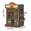 A miniature DIY book nook kit featuring a detailed shop facade with glass windows and a sign.