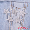 Set of five silver glitter star iron-on embroidered patches on a light blue denim fabric.