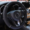 Black breathable faux leather steering wheel cover with diamond accents installed in a car interior.