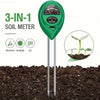 A green 3-in-1 soil meter with three probes inserted into dark soil, used to measure moisture, sunlight, and pH.