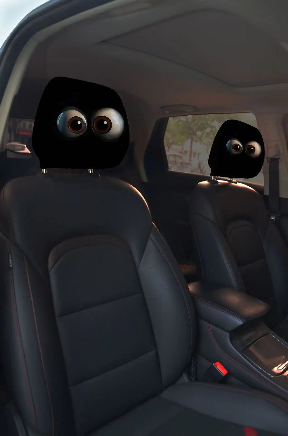 A pair of horror-themed car headrest covers featuring creepy face designs installed in a vehicle interior.