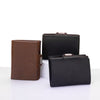 A black leather card holder wallet and a brown leather card holder wallet are displayed on a white surface.