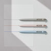 Three gel pens in white, pink, and light blue are displayed against a white background.