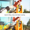 A hand is using a heavy-duty grease gun coupler with a quick-release double handle on a piece of machinery.