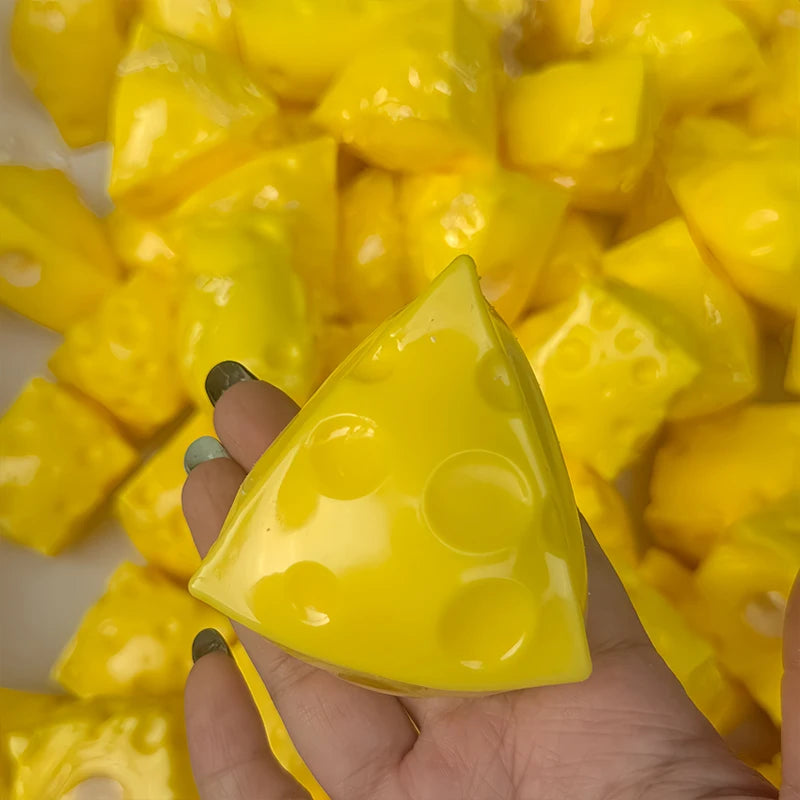 A hand holds a bright yellow, triangular fidget cube surrounded by other yellow cubes.