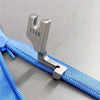 Stainless steel invisible zipper presser foot attached to a blue fabric strap.