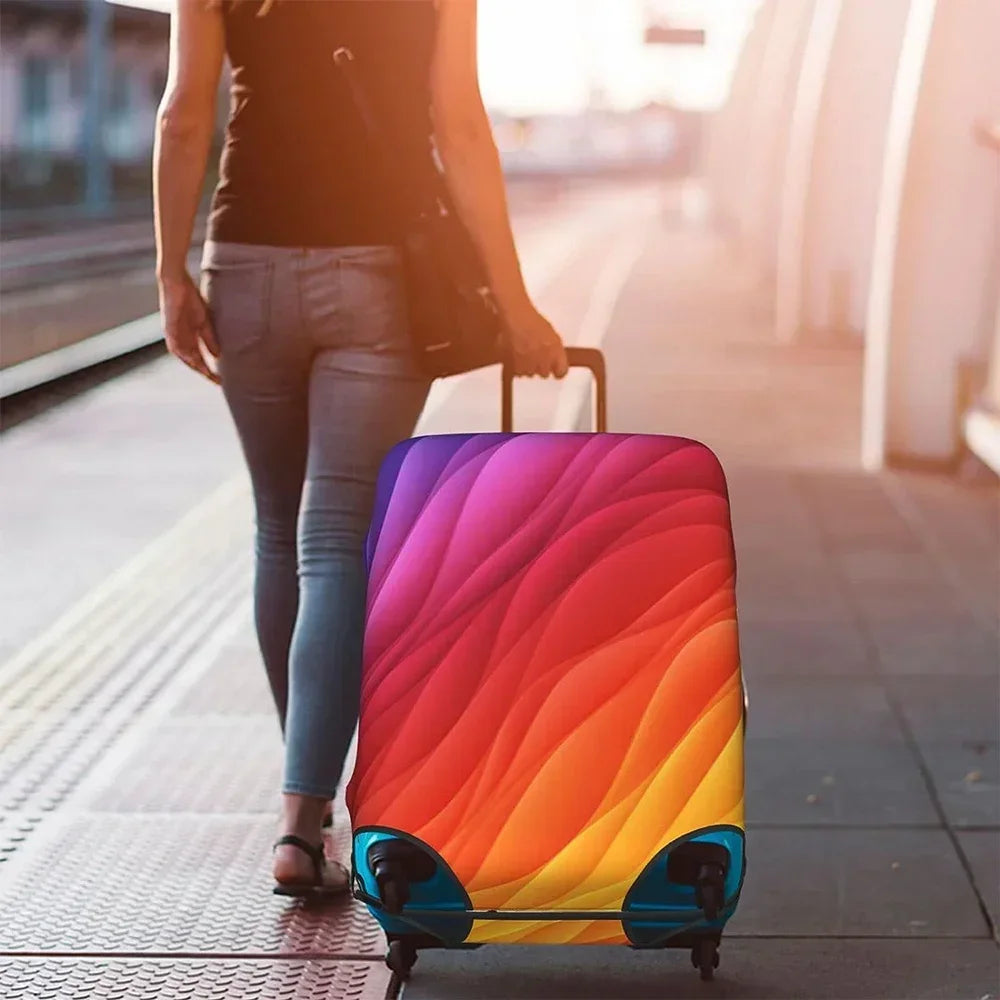 A person is pulling a brightly colored, multi-hued suitcase with a protective cover down a modern walkway.