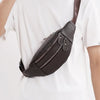 A dark brown genuine leather multi-pocket waist bag is shown against a white t-shirt.