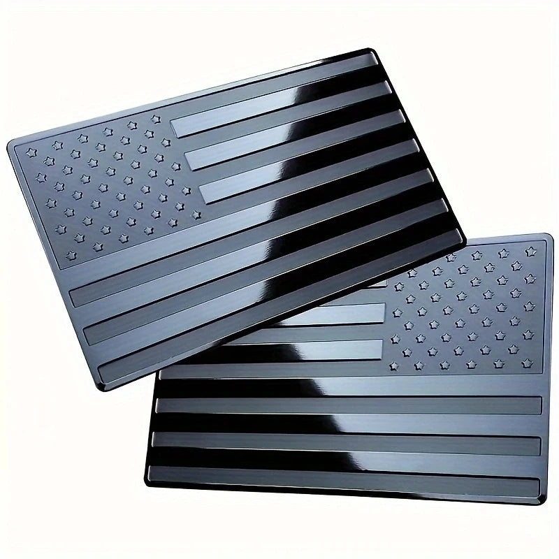 A set of matte black 3D American flag car emblems showing various stripes and stars.