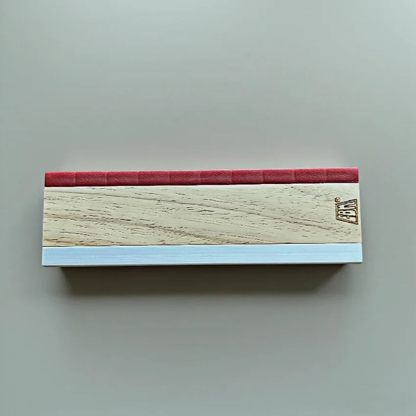 A wooden fingerboard ramp set featuring a quarter pipe and rail with a red top and light wood body.
