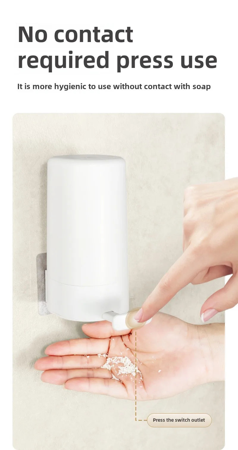 A hand is pressing the switch outlet on a white soap bar grinder and dispenser for no-contact press use.