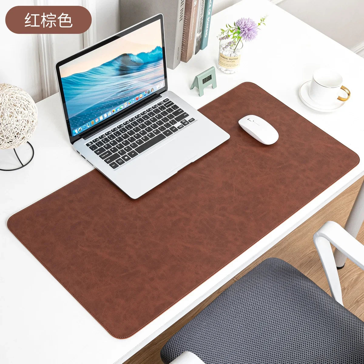 A brown waterproof PU leather desk pad is placed under a laptop and mouse on a white desk.