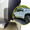 Close-up of a white truck mud flap delete cover and wheel shown on a vehicle.