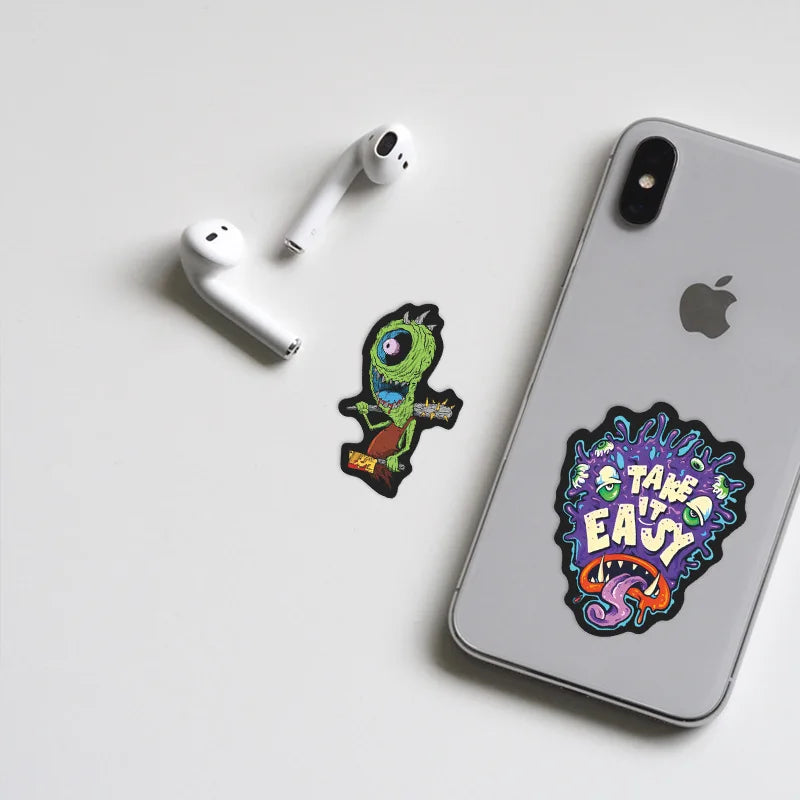 A white Apple AirPod case and a green skull sticker are displayed on a white surface.