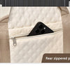 A cream-colored nylon travel duffle bag with a zippered pocket and tan straps.